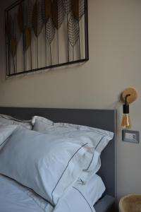 a bed with white pillows and a mirror on the wall at Pagum Place in Torrita di Siena