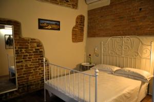 a bedroom with a bed and a brick wall at Pagum Place in Torrita di Siena +28 photos