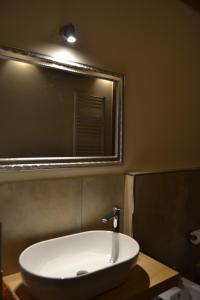 a bathroom with a white sink and a mirror at Pagum Place in Torrita di Siena