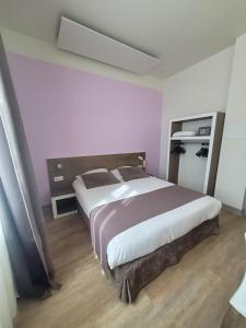 オランジュにあるHOTEL KYRIAD ORANGE Centre Ville - A7-A9 - 3 Etoiles - HOTEL DES PRINCES - Provence Alpes Côte d'Azur - Franceのピンクの壁のベッドルーム1室(大型ベッド1台付)