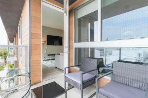 a balcony with glass chairs and a television on a building at New 2 Bedroom Modern Luxury Views WeHo in Los Angeles