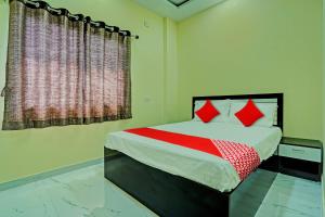 a bedroom with a bed with red pillows and a window at OYO Flagship Hotel Bliss Inn in Rāipur