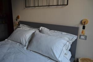 a bedroom with a bed with white pillows at Pagum Place in Torrita di Siena