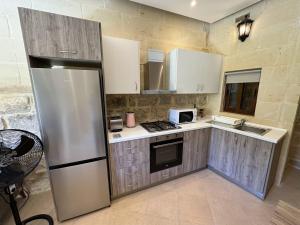 uma cozinha com um frigorífico de aço inoxidável e um micro-ondas em The Nest Siekel Townhouse em Għajn il-Kbira