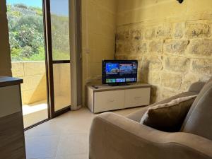 uma sala de estar com uma televisão sentada numa mesa em The Nest Siekel Townhouse em Għajn il-Kbira