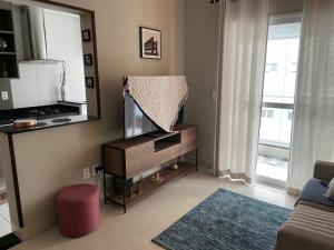 a living room with a tv and a mirror at Santos Linda!! Apartment for Business and Leisure. in Santos
