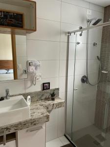 a bathroom with a glass shower and a sink at Santos Linda!! Apartment for Business and Leisure. in Santos