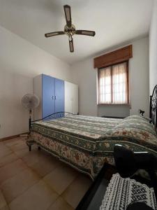1 dormitorio con 1 cama y ventilador de techo en Appartamento Evelynn, en Pizzo