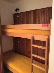 ヴァロワールにあるRésidence Plan Soleil - Studio pour 4 Personnes 64の二段ベッドが備わる木製の壁の客室です。