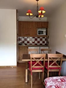een keuken met een tafel en stoelen in een kamer bij Les Chalets Valoria - 2 Pièces pour 4 Personnes 44 in Valloire