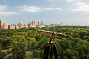 un telescopio mirando a una ciudad a lo lejos en The Ritz-Carlton New York, Central Park, en Nueva York
