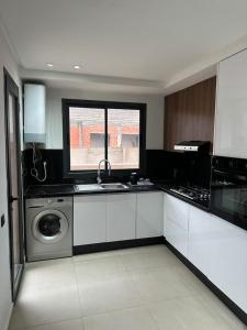a kitchen with a sink and a washing machine at Cosy Apartment Menara Garden in Marrakech