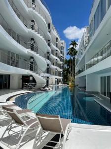 a swimming pool with chairs and a building at A2-stunning Seaview 4brs3baths Duplex karon City in Ban Karon