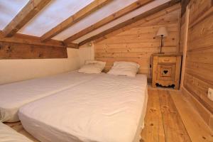 a bedroom with a bed in a wooden room at Résidence La Beguette - 2 Pièces pour 6 Personnes 54 in Notre-Dame-de-Bellecombe