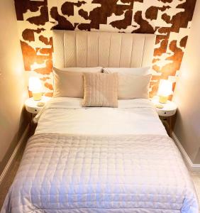 een slaapkamer met een groot wit bed met 2 lampen bij Character filled Courtyard Escape in Harrogate