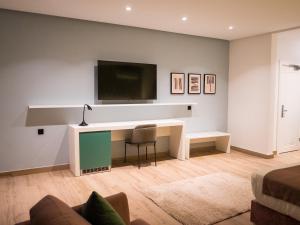 a living room with a desk and a tv on a wall at HOTEL HIBA in Nouakchott