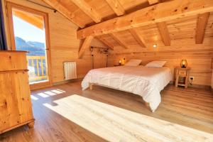 1 dormitorio con 1 cama en una cabaña de madera en Résidence Le Champ De La Caille - Chalets pour 8 Personnes 54 en Notre-Dame-de-Bellecombe