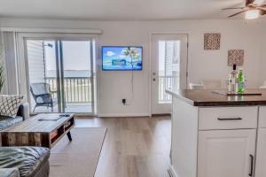 Una cocina y una sala de estar con un sofá y una mesa. en New Bethany Ocean View Condo by the sea 2nd of 2, en Cedar Shores