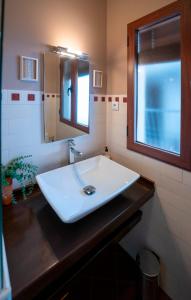 uma casa de banho com um lavatório branco e um espelho. em El Cervunal em Arenas de San Pedro