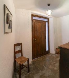 um quarto com uma porta de madeira e uma cadeira em El Cervunal em Arenas de San Pedro