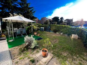 a garden with a white umbrella and some plants at Apartma Nataša in Jagodje