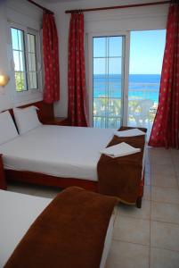 um quarto com 2 camas e vista para o oceano em Hotel Smaragdi em Chrysi Ammoudia