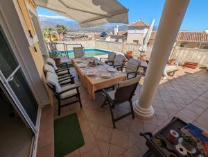 un patio con mesa, sillas y piscina en Viña Home en Torre del Mar