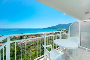 uma varanda com mesa e cadeiras e vista para o oceano em Hotel Smaragdi em Chrysi Ammoudia