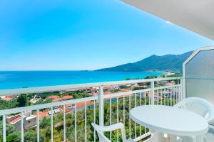 uma varanda com mesa e cadeiras e vista para o oceano em Hotel Smaragdi em Chrysi Ammoudia