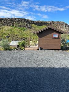 un pequeño edificio al lado de una montaña en Hlíðarás Guesthouse en Ölfus