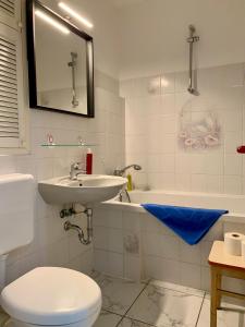 La salle de bains est pourvue d'un lavabo, de toilettes et d'une baignoire. dans l'établissement Home Wilma, à Berlin