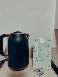 a blue tea kettle and a box on a table at Whimsical Land in London
