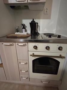 a kitchen with a white stove top oven in a kitchen at Trekker's Haven: Noux National Park Retreat in Espoo