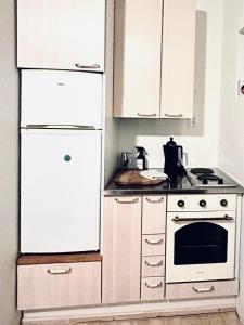uma cozinha com armários brancos e um forno de fogão branco em Trekker's Haven: Noux National Park Retreat em Espoo