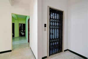 um corredor com um portão preto num edifício em The Blue Pearl Hotel em Calcutá