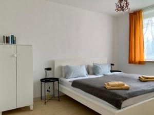 Habitación blanca con cama grande y lámpara de araña. en Home Wilma en Berlín