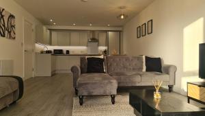 a living room with a couch and a chair and a kitchen at Premium CITY APARTMENT near Harry Potter Studio and Luton Airport in Hemel Hempstead