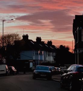 um carro a descer uma rua com um pôr-do-sol em Whimsical Land em Londres