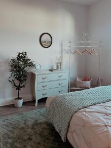 a bedroom with a bed and a dresser and a plant at Whimsical Land in London