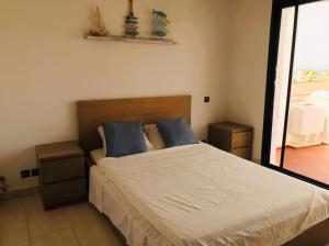 um quarto com uma cama grande e almofadas azuis em My Cosy Place Rabat - Maison harhoura piscine vue mer em Temara