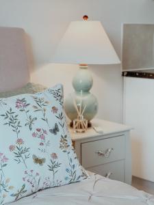 a bed with a pillow and a lamp on a nightstand at Whimsical Land in London