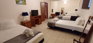 pokój hotelowy z 2 łóżkami i telewizorem w obiekcie Villa Ramos w Albufeirze