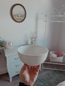 a person holding a white bowl in a bathroom at Whimsical Land in London