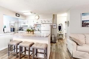 eine Küche und ein Wohnzimmer mit einer Bar und einem Sofa in der Unterkunft Waccamaw Condo - Unit 6 in Myrtle Beach