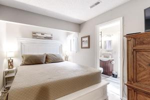 ein Schlafzimmer mit einem Bett und ein Badezimmer mit einem Waschbecken in der Unterkunft Waccamaw Condo - Unit 6 in Myrtle Beach