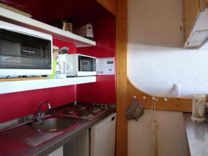 eine kleine Küche mit einer Spüle und einer Mikrowelle in der Unterkunft Résidence Nova - 2 Pièces pour 6 Personnes 214 in Arc 1800