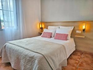 a bedroom with a large bed with two red pillows at Los Molinos in Sanlúcar de Guadiana