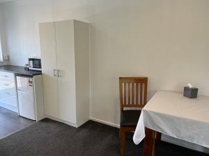 a small room with a table and a kitchen at Magnolia Court Motel in Opotiki