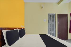 a bedroom with a bed with a black and yellow wall at OYO Thulasi Residency in Srīrangam