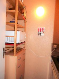 Una cocina con refrigerador y una luz en la pared. en Résidence Phenix - STUDIO CABINE 4/5 PERSONNES MAE-9844, en Le Corbier